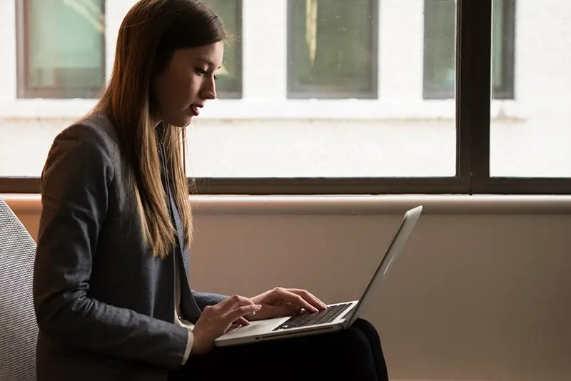 Woman sitting down and using her laptop