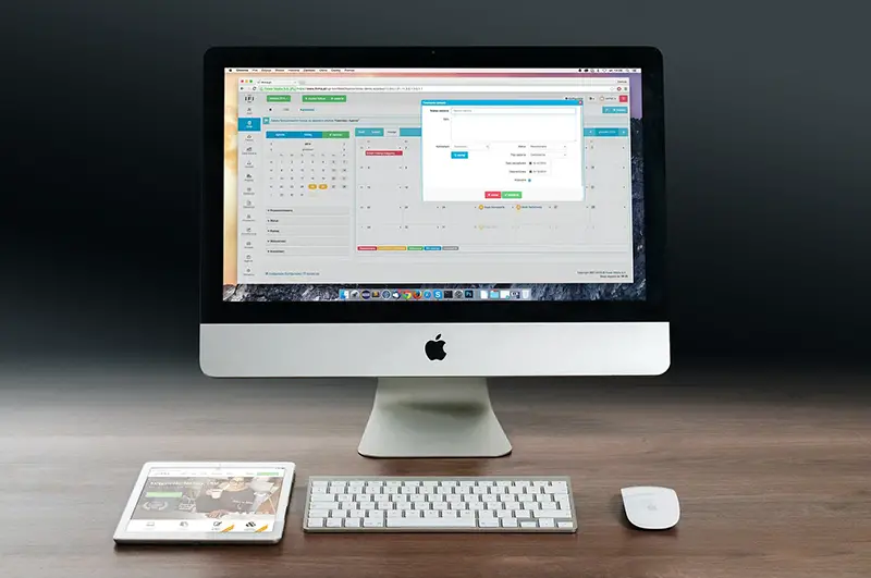 Imac and Ipad on the top of wooden table