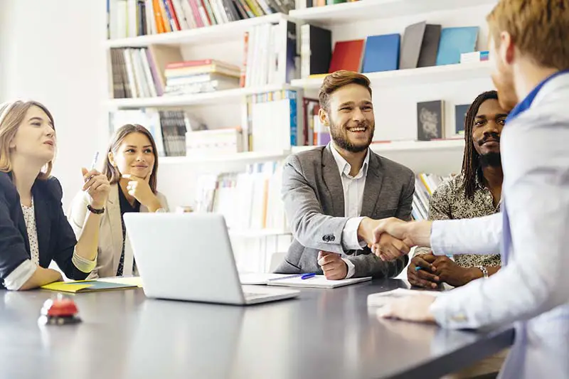 Businessmen shaking hand with a client in office