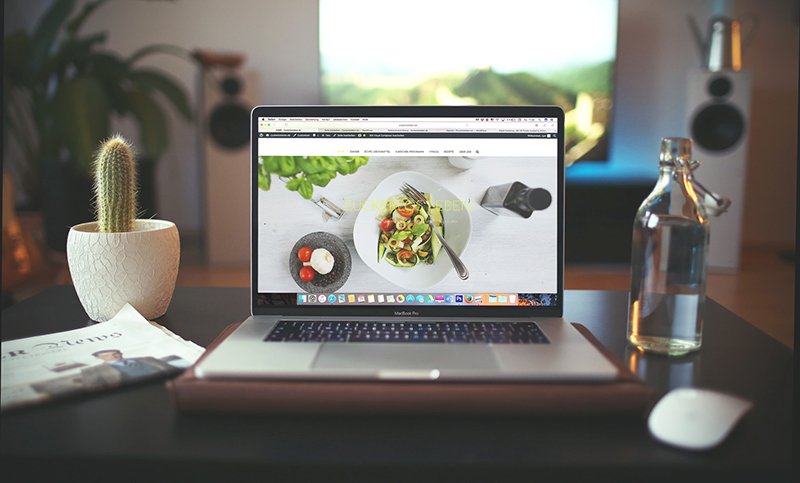 Photo of restaurant website rendered on a laptop on a desk.