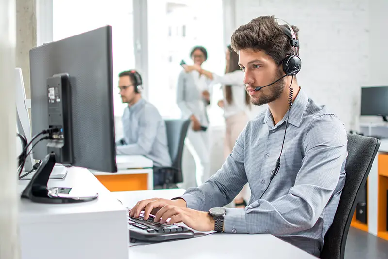 male customer support phone operator with headset working in call center.