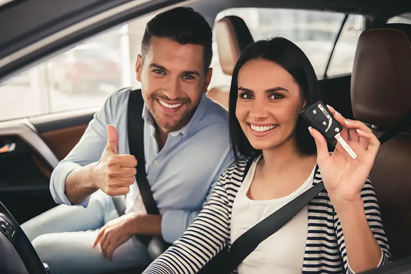 couple is holding a car key