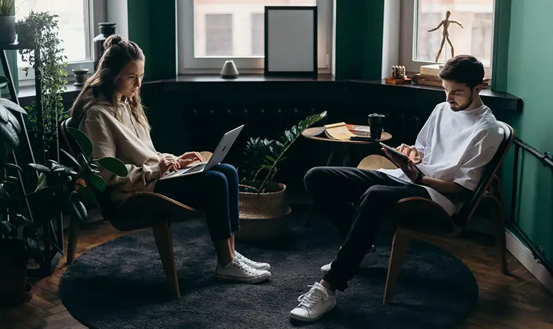 Two persons using their gadgets