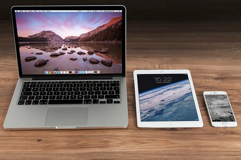 Macbook pro beside iPad and mobile phone on the top of wooden desk