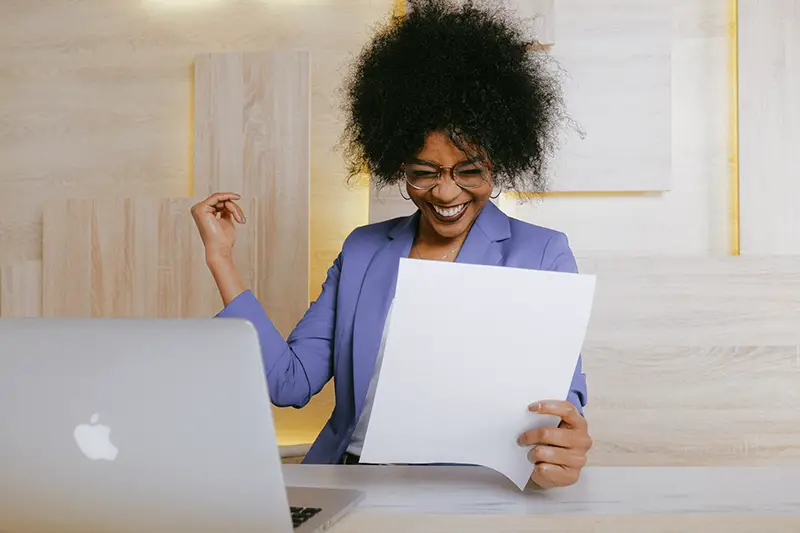 woman wearing purple blazer holding a paper