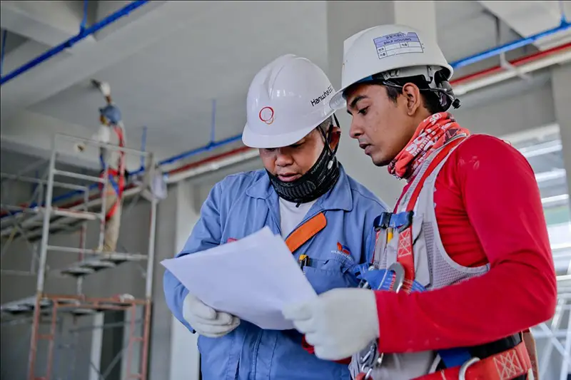 Two construction men wearing safety hats