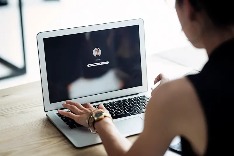 A woman is typing the password in her laptop computer