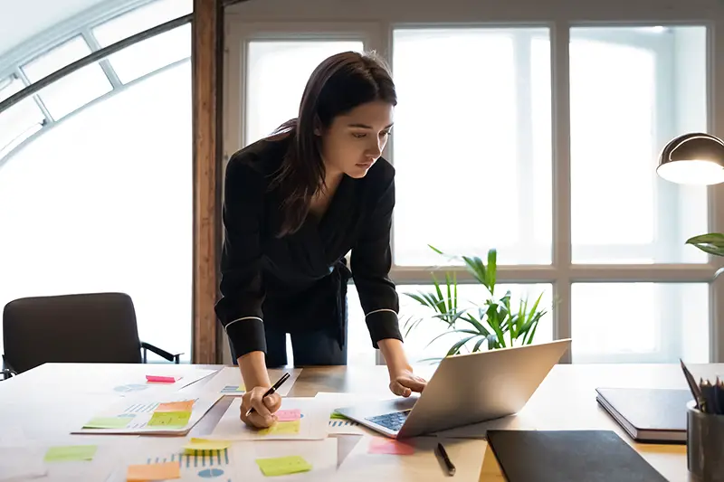 Young female business owner standing at the front of her computer