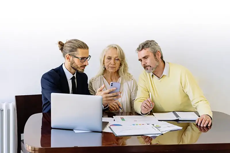 Male agent showing his mobile phone to a senior couple client