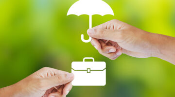 Business insurance concept with an umbrella covering business briefcase