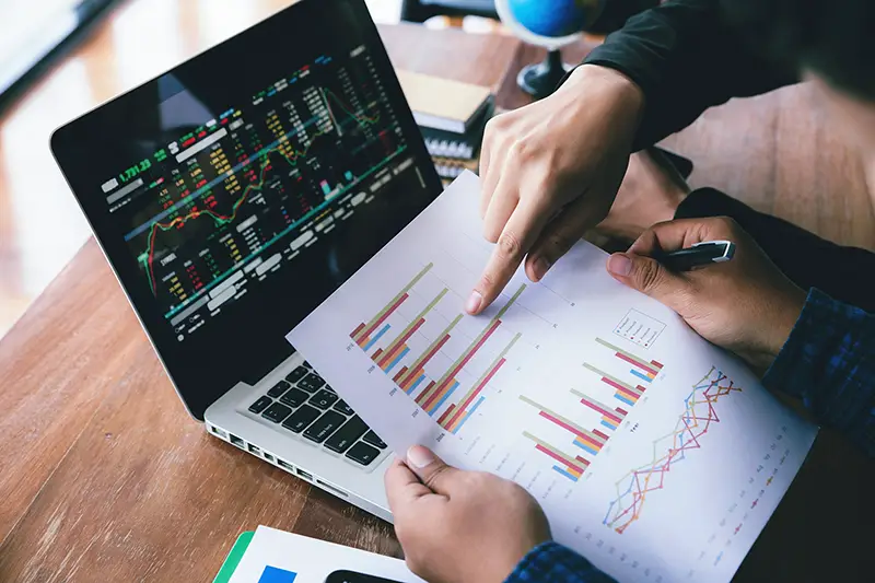 Business man hand holding pen and pointing graph chart