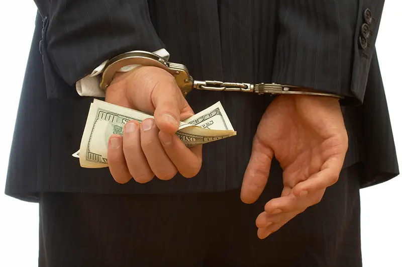 business crime concept with handcuffs and dollar