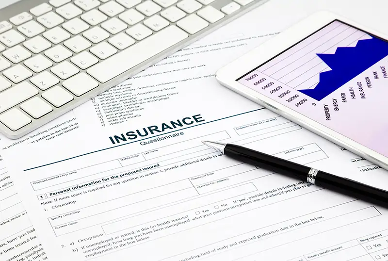 insurance questionnaire and tablet on office table