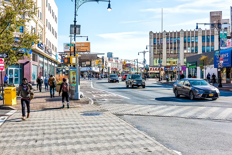 People crossing street in Fordham Heights center