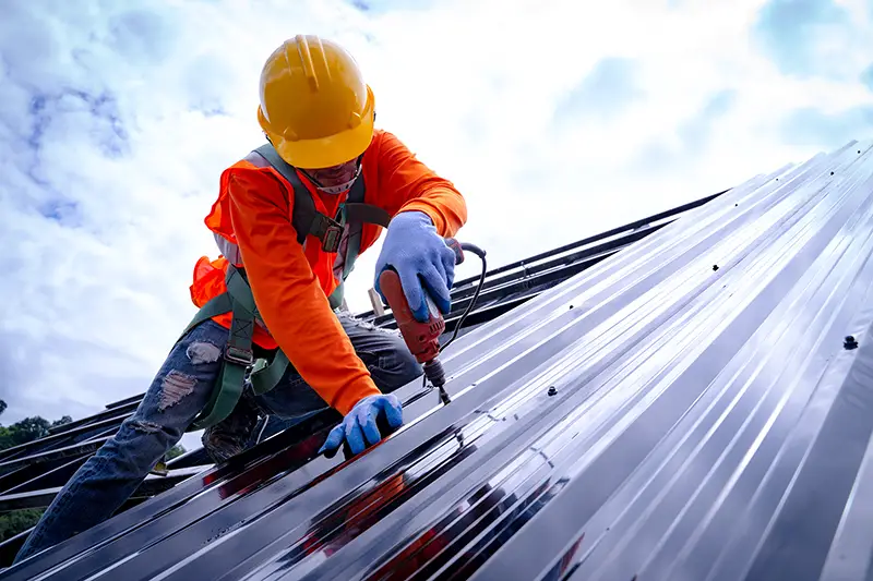 Roofer working on roof structure of building on construction site