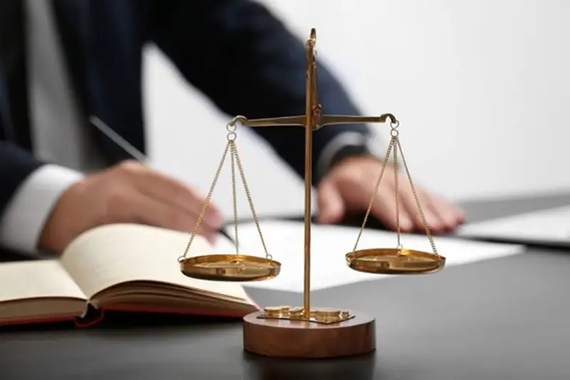 Justice scale and a lawyer in the background