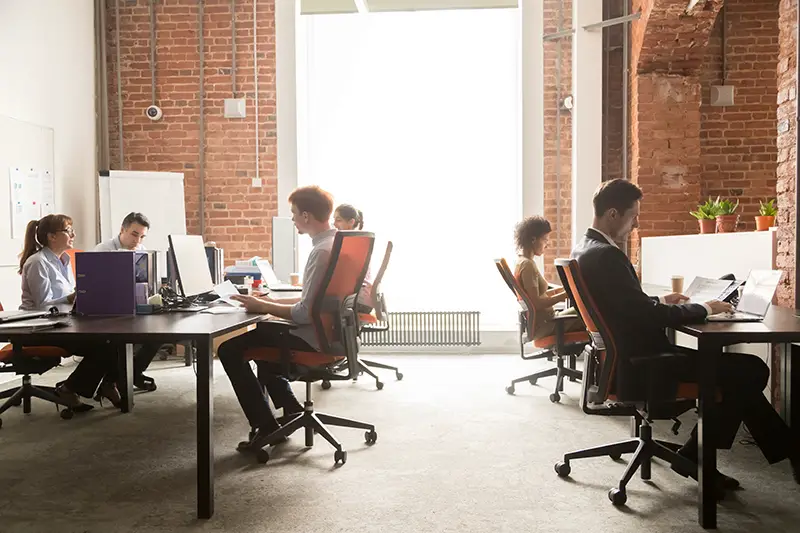 Business team women and men workers working on computers in modern office