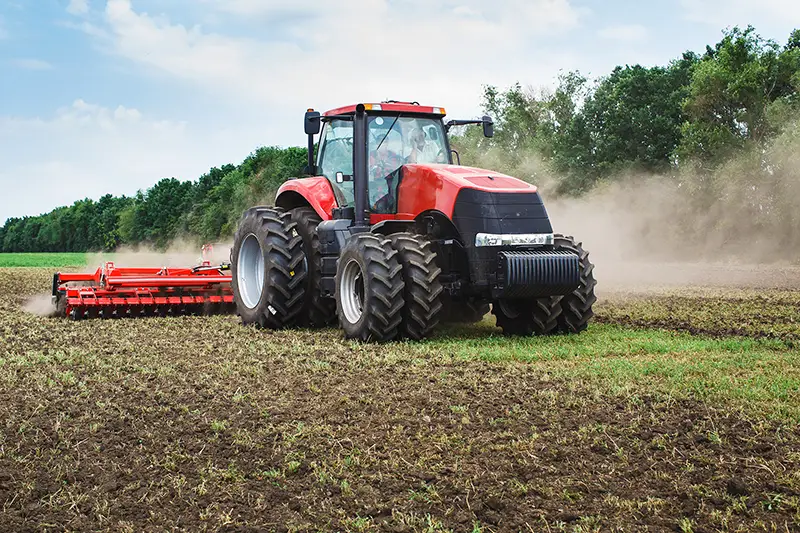 modern red tractor in the agricultural field