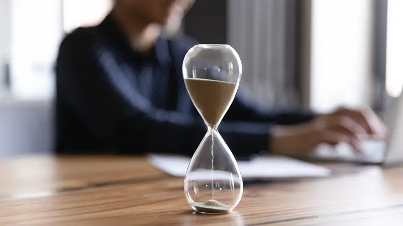 Close up view of hourglass stand on wooden home office measuring time