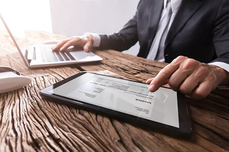 Close-up Of A Businessman's Hand Working With Invoice On Digital Tablet