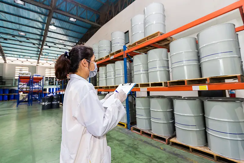 Employees inspecting industrial oil tanks in a warehouse