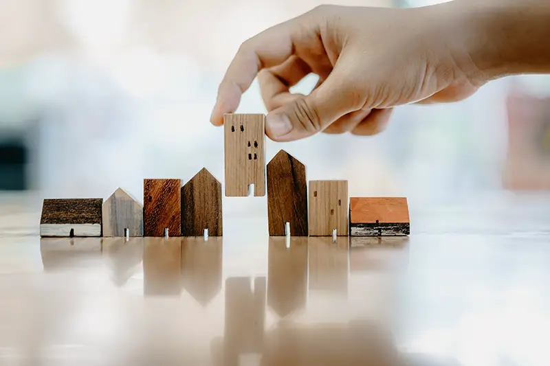 Hand choosing mini wood house model