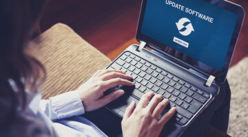 Woman updating laptop computer software sitting at home