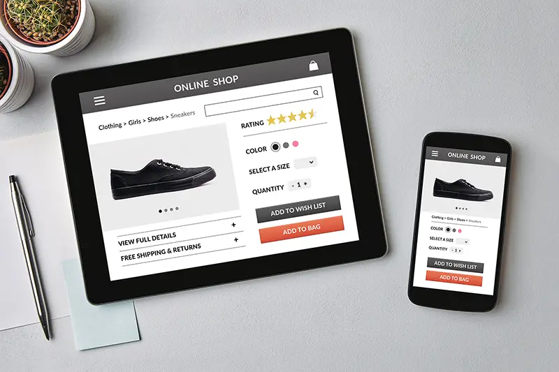 Online shop concept on tablet and smartphone screen over gray table