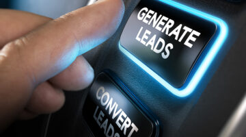Hand about to press a generate leads button with blue light over black background
