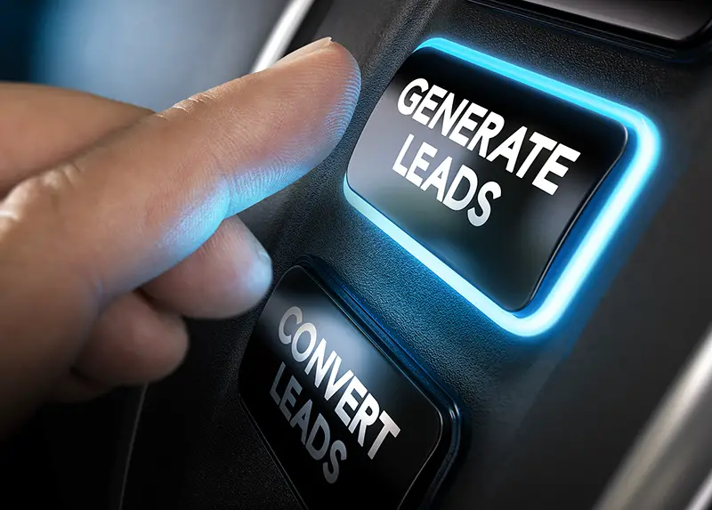 Hand about to press a generate leads button with blue light over black background