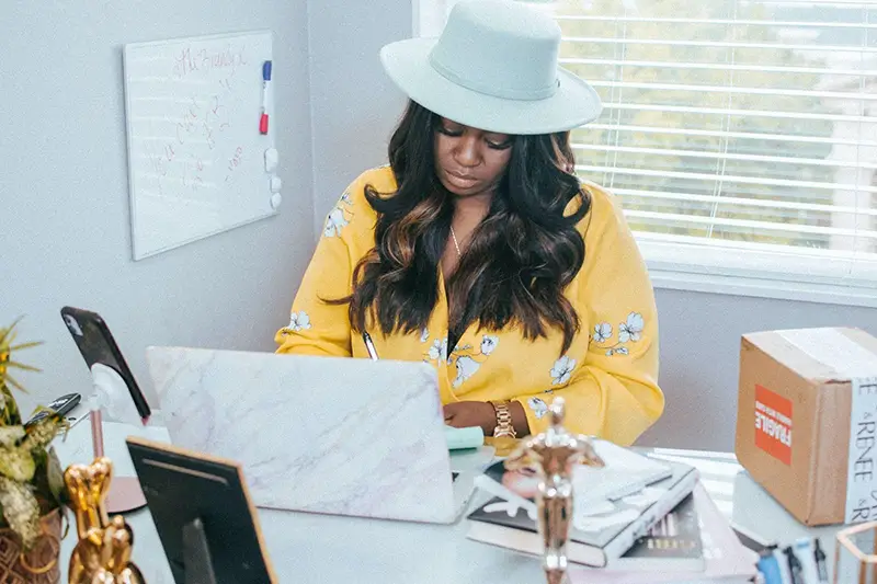 Woman wearing hat working on her desk