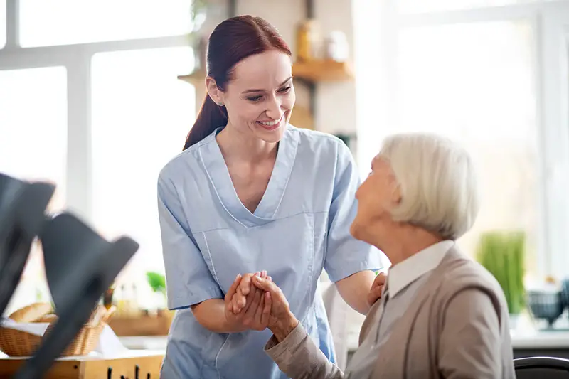 Woman caregiver helping the elder woman