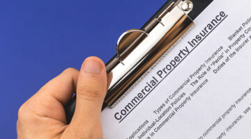 Man hold commercial property insurance claim form and policy