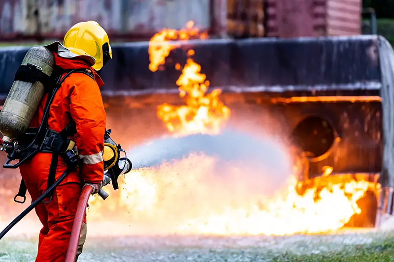 Firefighter using Chemical foam fire extinguisher to fighting with the fire flame