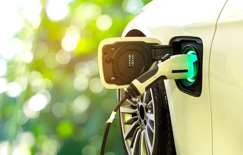 Electric car at charging station with the power cable supply plugged in