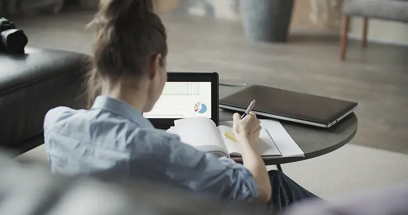 Girl sitting on sofa and using digital tablet computer in home