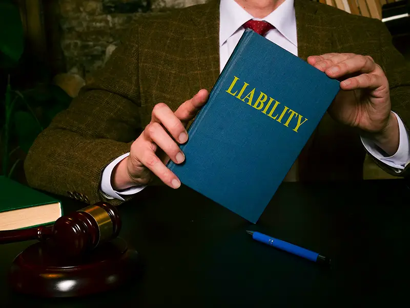 The lawyer at the table shows a book liability law