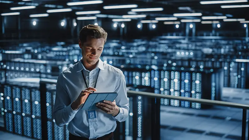 IT Specialist Using Tablet Computer in Data Center