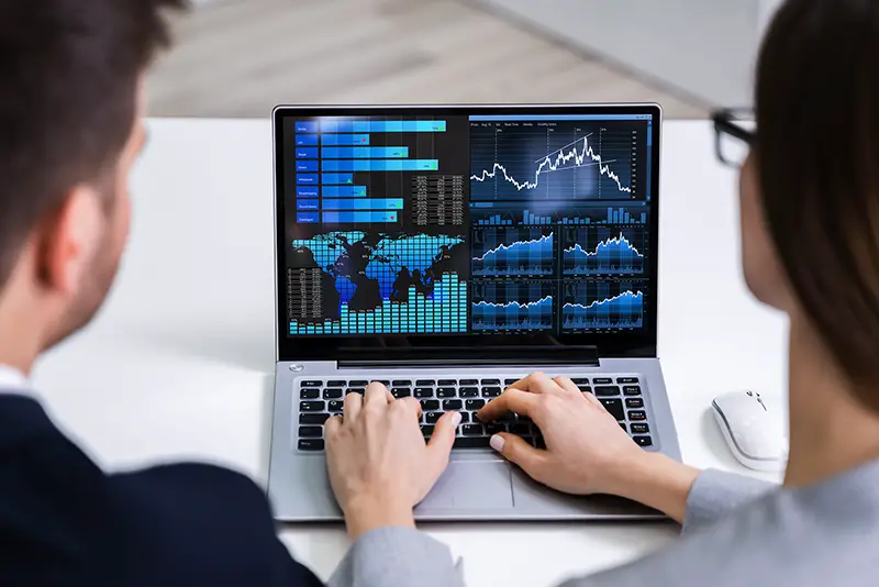 Two Businesspeople Analyzing Financial Graph On Laptop