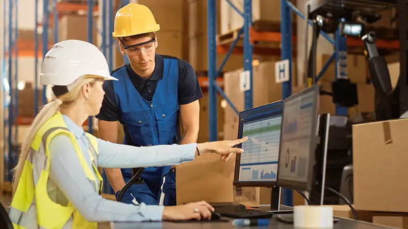 In Retail Warehouse Manager Uses Computer with Inventory Checking Software, Talks with Storehouse Worker about Package Delivery. International Distribution Center with Shelves Full of Products