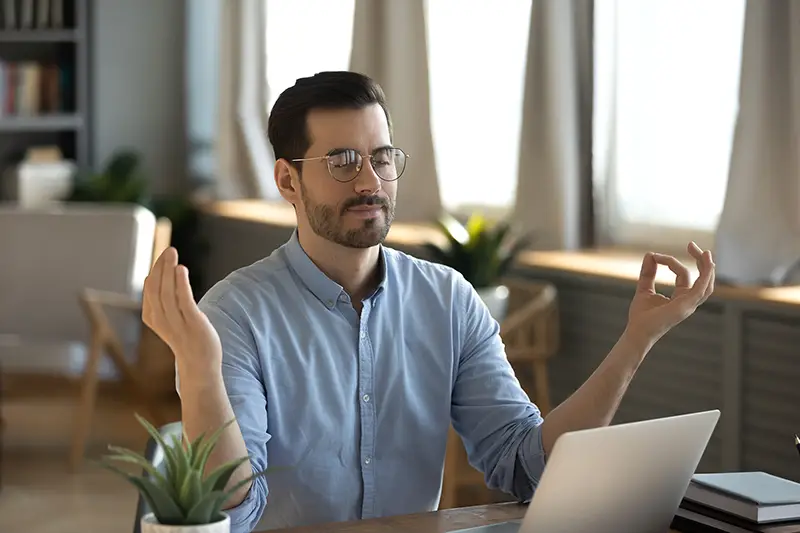 office male employee sit at desk relaxing doing yoga