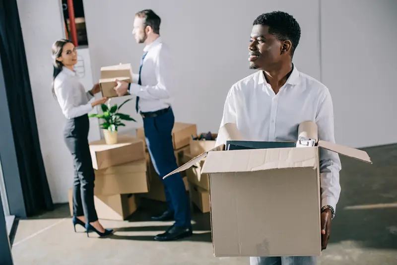 smiling african american businessman holding cardboard box