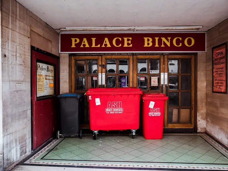 Red dumpster in the front of building entrance