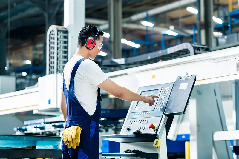 Worker entering data in CNC machine