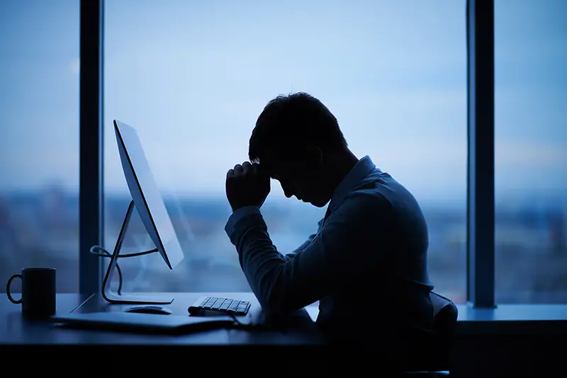 stressed businessman sitting in front of computer in office