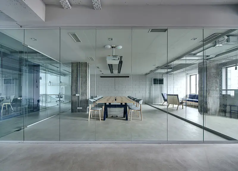 Office in a loft-style with white brick and glass walls. 