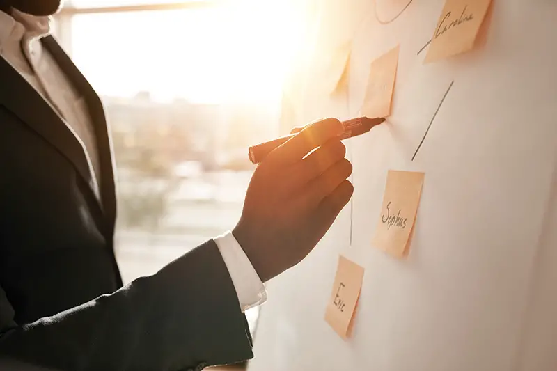 Cropped shot of businessman putting his ideas on white board