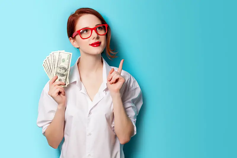 women in red glasses with money on blue background