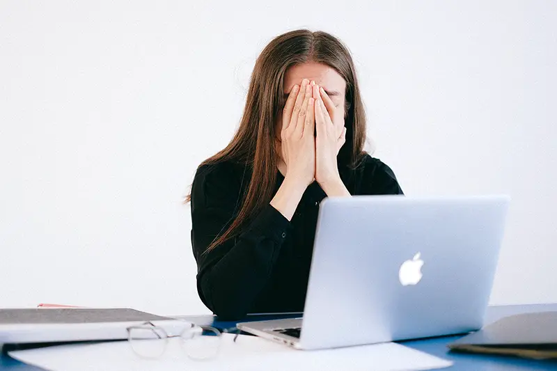 Woman covering her hands on her face