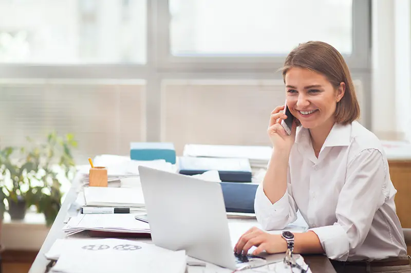 Young woman working on laptop and smiling